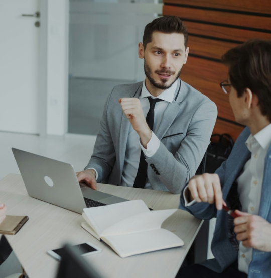 Four professionals in a business meeting around a table.